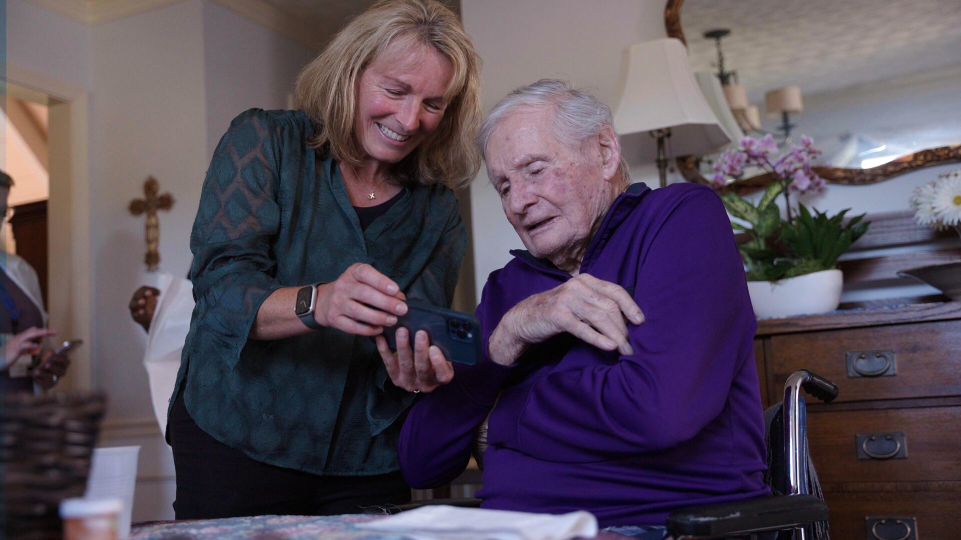 Healthcare professional consulting with elderly patient at home during medication management visit