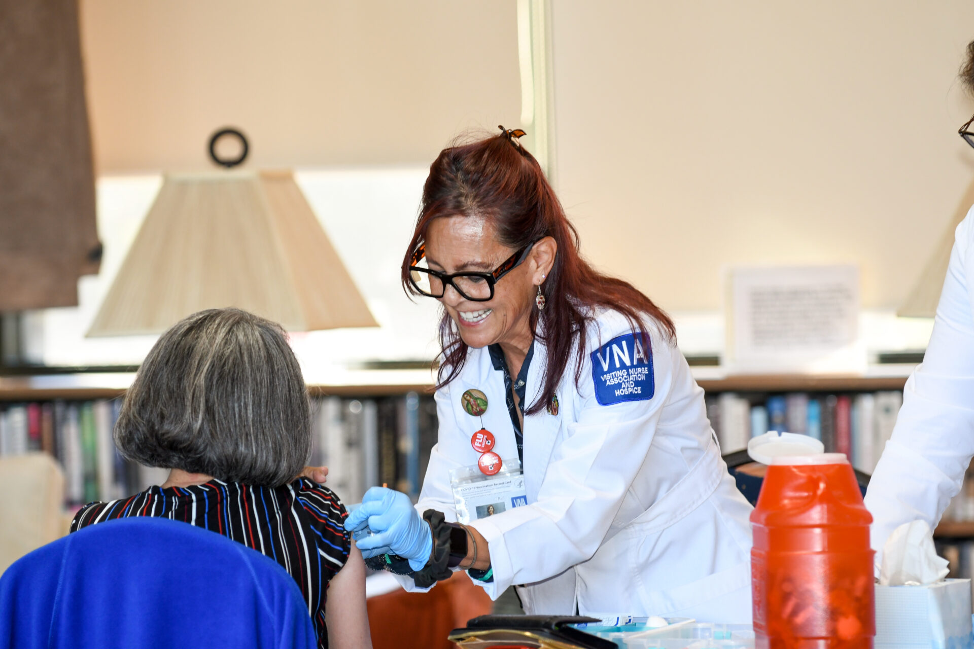 Healthcare provider administering care to patient in clinical setting with medical supplies visible